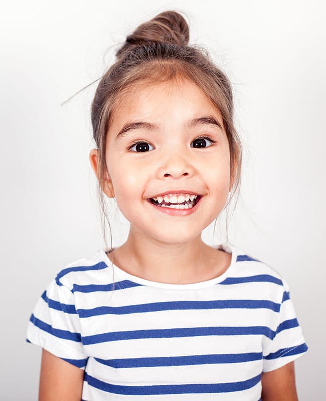 Smiling girl wearing a striped shirt and her hair tied up her head